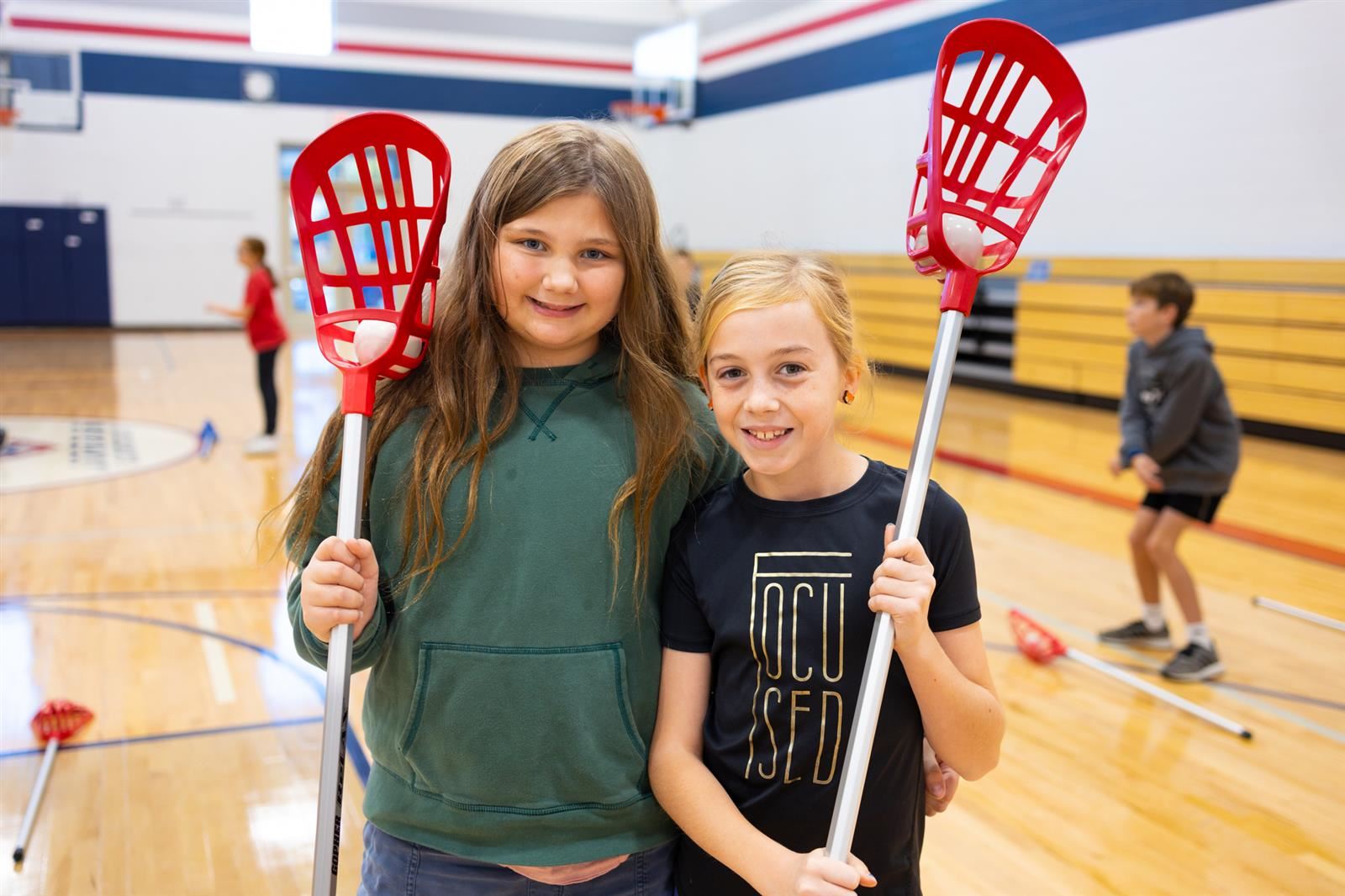 Two girls holding lacrosse sticks